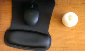Flameless candle beside mouse pad
