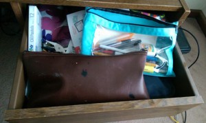 Desk drawer full of old pencils, pens, and other junk.