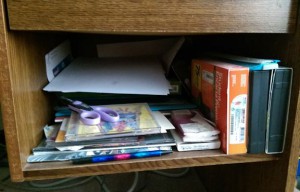 Desk shelf full of clutter.