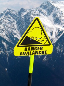 Avalanche warning sign with mountains in background