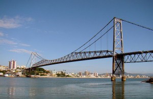 Long suspension bridge with city in background.