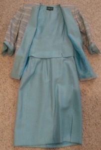 Suit with striped jacket and blue skirt and vest.