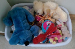 Laundry basket full of dog toys and stuffed animals.