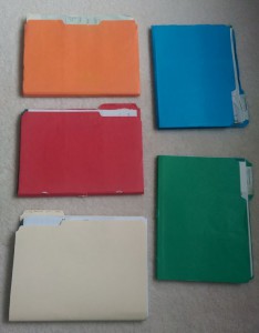 Five old file folders with bank statements in them.