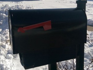 New black mailbox on post, with snow all around.