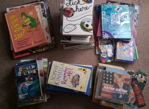 Stacks of children's books and other bookcase clutter.