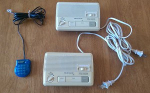 Set of two portable intercom devices and a toy phone.