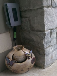 Small ceramic garden fountain decorated with butterflies and flowers, in a corner of my porch.