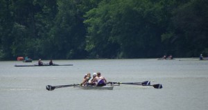 People in small boats rowing on a river.