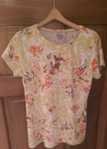 Short-sleeved blouse with an autumn leaf pattern in pale green, rust red, and shades of brown.