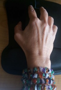 My hand on a mousepad with crystal beads wrapped around my wrist four times.