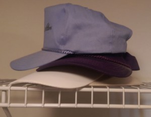 Stack of hats on a closet shelf.