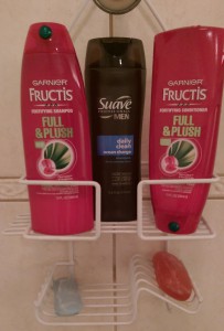 Shower caddy with men's shampoo between women's shampoo and conditioner.