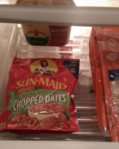 Bag of chopped dates in a refrigerator drawer next to butter and cheese.