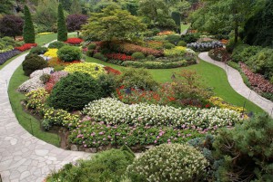 Garden with flowers, shrubs, and winding stone paths.