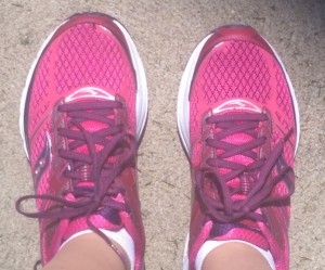 Pink running shoes on concrete.