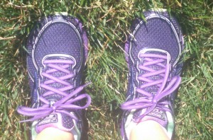 Purple running shoes in grass.