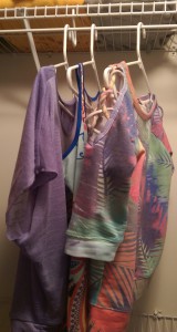 Three pretty new tops in purple and other spring colors, hanging in my closet.