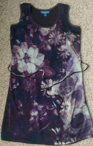 Dark purple sleeveless dress with white floral pattern.