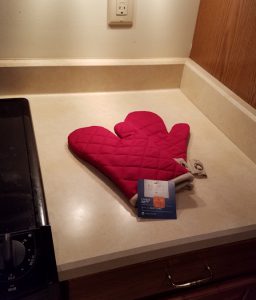 Pair of red oven mitts on the kitchen counter.