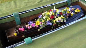 Casket covered in flowers.