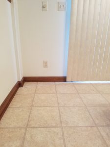 Empty corner of my kitchen, with bare walls and vertical blinds.