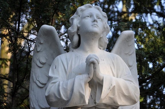 Statue of angel with hands clasped.