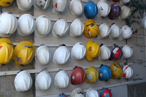 Rows of hard hats hanging on a wall.