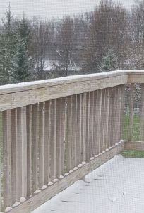 Snow on my deck in April, with trees still bare.