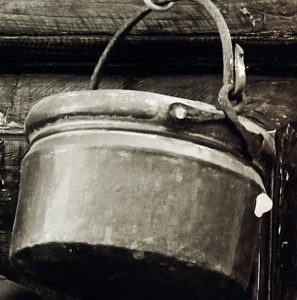 Old pot hanging on a hook.