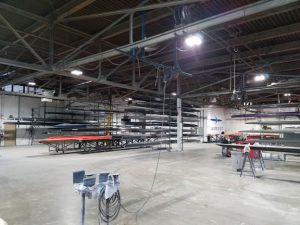 Factory floor with boats stacked up on racks.