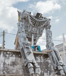 Large robot leaning over a wall.