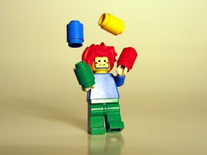 A Lego person juggling Lego pieces.