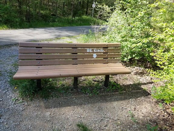 Photo of a park bench with BE KIND painted on it.