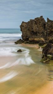 Photo of a river meeting the ocean.