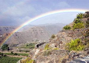 Photo of sunny hills and a rainbow.