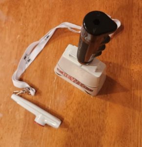 Photo of a cowbell and kazoo on a table.