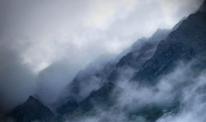 Photo of jagged mountains in clouds.