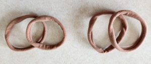 Photo of four small brown hair bands.