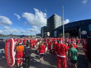 People in Santa costumes at a walk and run event in Auckland.