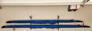 Photo of two new single sculls in boat bags in the garage.