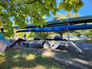 Boat trailer parked at Head of the Charles under a blue sky.